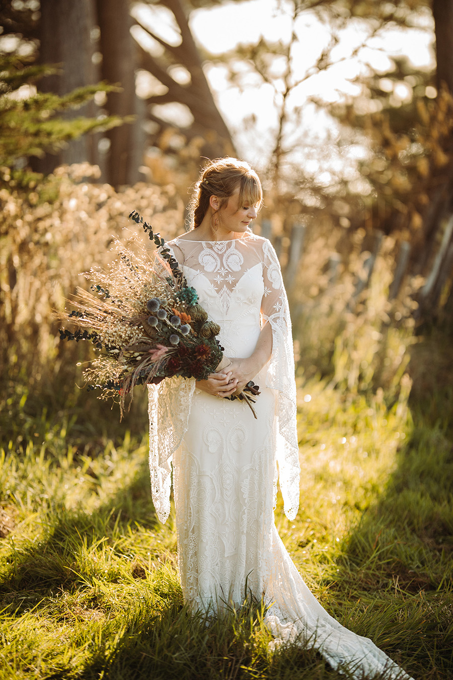 bride standing in front of the forest